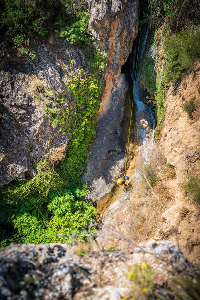 Неузнаваемые лица каньонинг с веревками под ручей - Фото, изображение