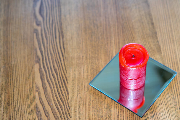Une épaisse bougie rouge se tient sur la table. Vue latérale. Place pour le texte - Photo, image