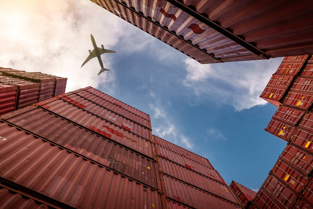 Airplane flying above container logistic. Cargo and shipping business. Container ship for import and export logistic. Logistic industry from port to port. Container at harbor for truck transport.  - Photo, Image