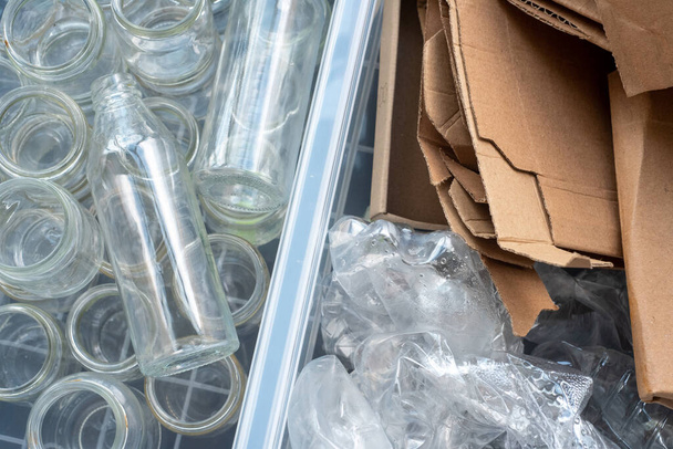 Пластиковые бутылки, стекло и картон сортируются для переработки. - Фото, изображение
