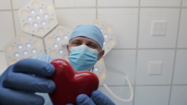 Kirurgi antaa sydämen potilaalle, joka makaa leikkauspöydällä - Materiaali, video