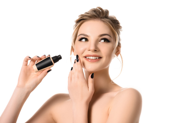 smiling naked beautiful blonde woman with makeup and black nails holding face foundation isolated on white - Foto, Imagem
