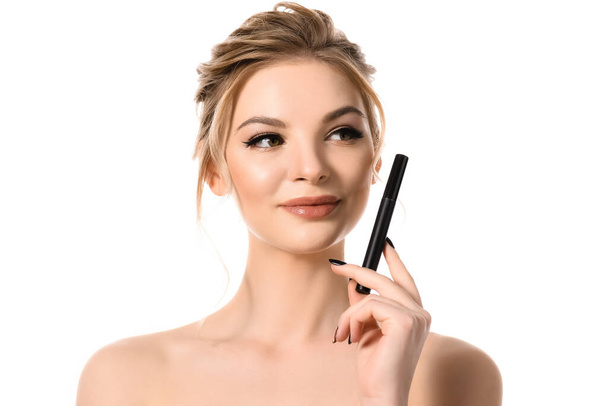 smiling naked beautiful blonde woman with makeup and black nails holding mascara isolated on white - Фото, изображение