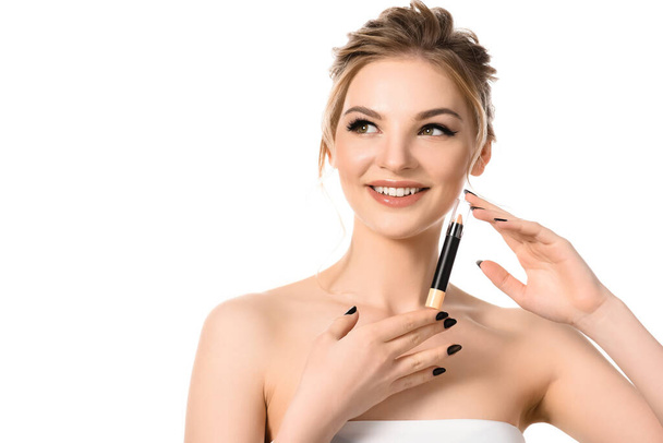 smiling beautiful blonde woman with makeup and black nails holding stick concealer isolated on white - Photo, Image
