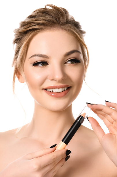 smiling naked beautiful blonde woman with makeup and black nails holding stick concealer isolated on white - Φωτογραφία, εικόνα