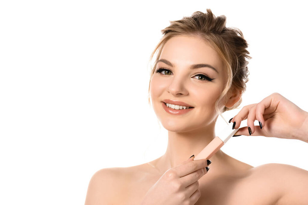 smiling naked beautiful blonde woman with makeup and black nails holding beige lip gloss isolated on white - Photo, Image