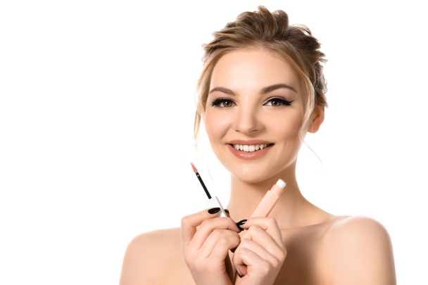 smiling naked beautiful blonde woman with makeup and black nails holding beige lip gloss isolated on white - 写真・画像