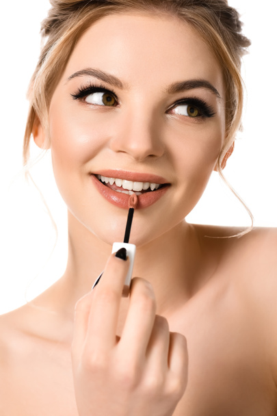 sorrindo nu bela mulher loira com maquiagem e unhas pretas aplicando lustro de lábio bege isolado no branco
 - Foto, Imagem