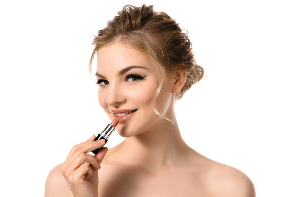 smiling naked beautiful blonde woman applying beige lipstick isolated on white - Фото, зображення