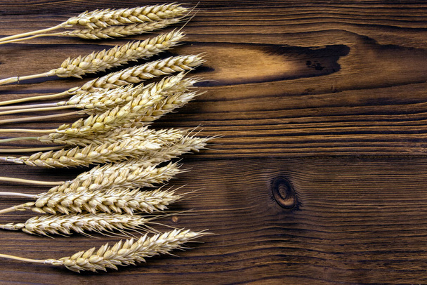 Ears of wheat on a dark wooden background. - Valokuva, kuva
