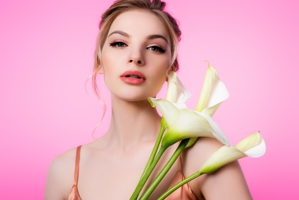 elegante hermosa mujer rubia sosteniendo flores de calla aisladas en rosa
 - Foto, Imagen