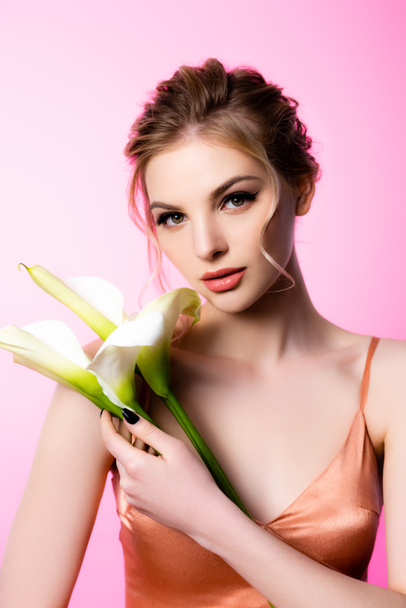 elegant beautiful blonde woman holding calla flowers isolated on pink - Photo, Image
