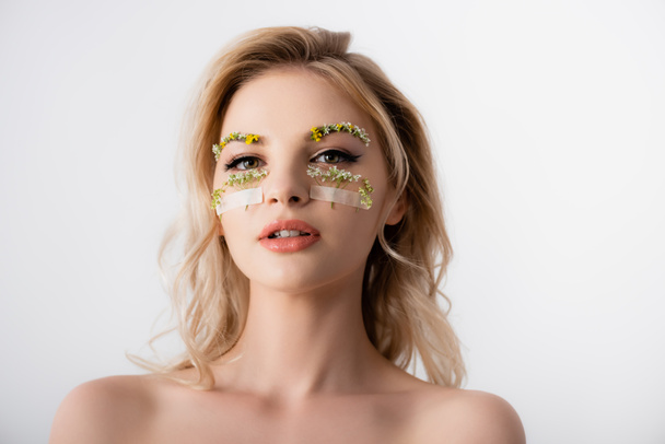naked beautiful blonde woman with wildflowers under eyes isolated on white - Photo, image