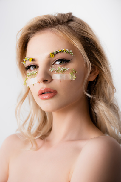 naked beautiful blonde woman with wildflowers under eyes isolated on white - Fotó, kép