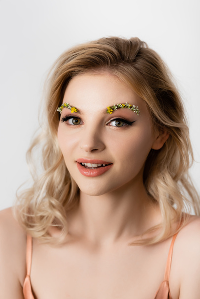 beautiful blonde woman with wildflowers on eyebrows isolated on white - Foto, imagen