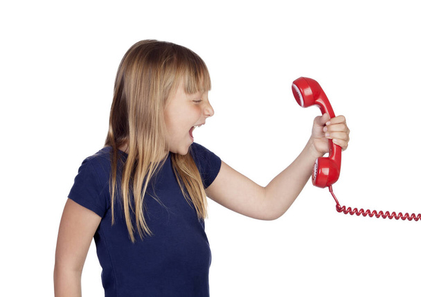 Забавная маленькая девочка кричала с красным телефоном на белом фоне - Фото, изображение