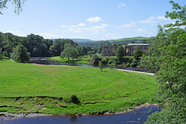Wharfedale jest uważane przez wielu za klejnot w koronie wszystkich dales w Yorkshire Dales. Niezwykle popularny wśród turystów, zawiera zachwycające widoki na łagodne faliste wzgórza, nabrzeże rzeki i opactwo Bolton, aby wymienić tylko kilka. - Zdjęcie, obraz