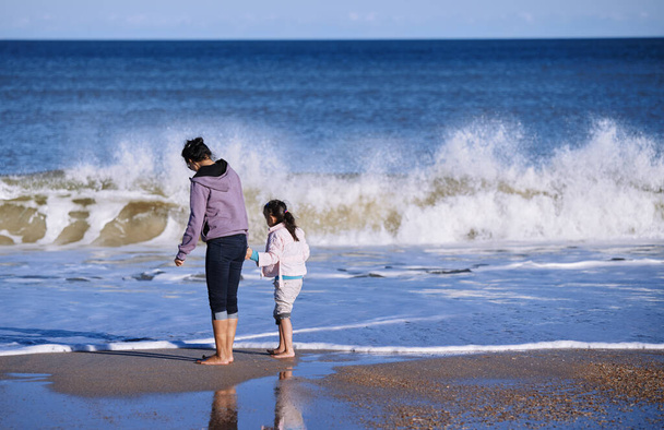 Onnellinen äiti ja tytär meren rannalla - Valokuva, kuva