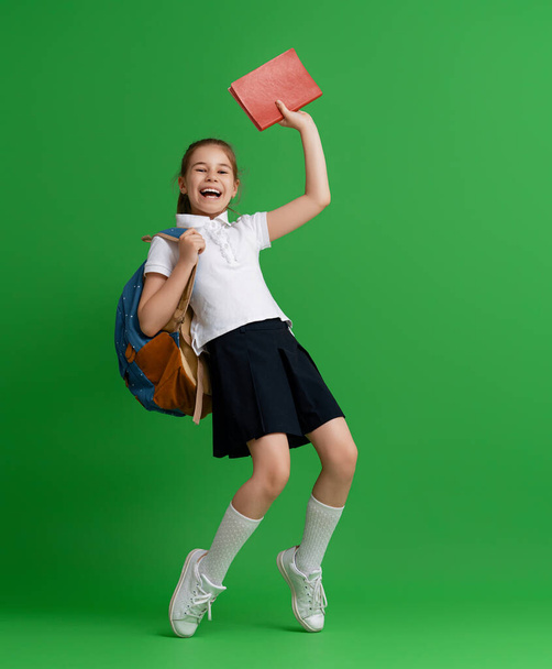 Back to school and happy time! Cute industrious child on color paper wall background. Kid with backpack. Girl ready to study. - Valokuva, kuva