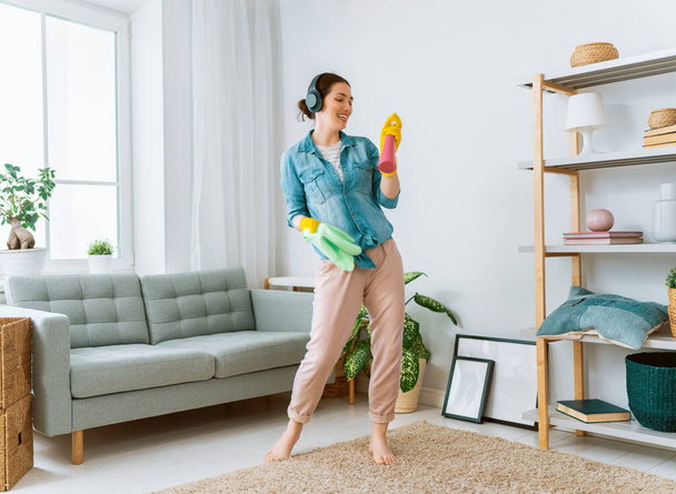 Beautiful young woman doing cleaning the house. - 写真・画像