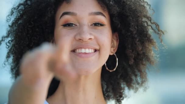 Happy attractive ethnic American pretty student girl pointing finger to camera and inviting to get good education abroad. Beautiful African woman invites you to go to holiday sales discounts in stores - Video, Çekim
