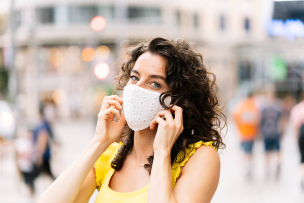 Brunette woman with a facial mask in the city - Foto, afbeelding