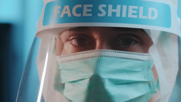 Female nurse working ooking up with face mask and shield covering - Video