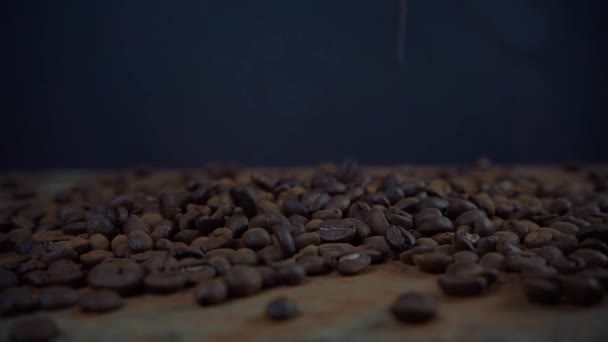 Zeitlupenaufnahmen von Kaffeebohnen, die auf einen schwarzen Hintergrund fallen - Filmmaterial, Video