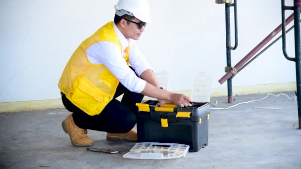 İnşaat mühendisi takım çalışması güvenlik ekibi, inşaat sahasında beyaz sarı şapkalı güvenlik ekipmanı tutuyor. Hardhat İnşaat Mühendisliği Mühendisliği Yöneticisini Koru - Video, Çekim