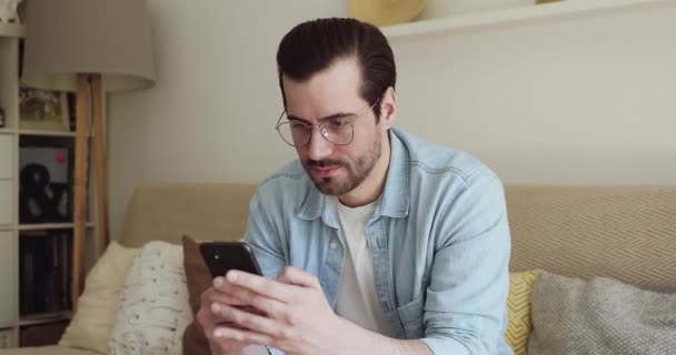 Man using smartphone playing games, makes a bet online gambling - Video, Çekim