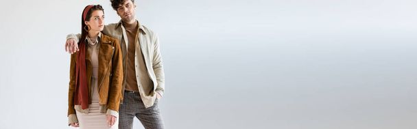 webside header of young, stylish couple in autumn clothes posing on grey - Photo, Image