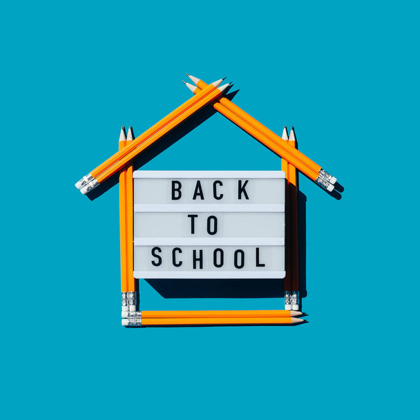 Lightbox com a inscrição de volta à escola e uma casa feita de lápis. Escola em casa. Ensino à distância
. - Foto, Imagem