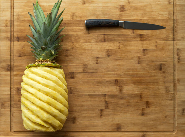Ripe perfectly peeled pineapple, on a wooden background. - Photo, Image
