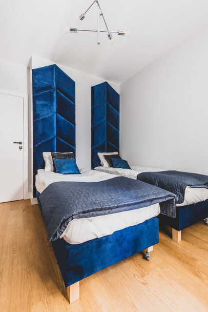 Удобная спальня с двумя кроватями в квартире в аренду. Дизайн интерьера - Фото, изображение