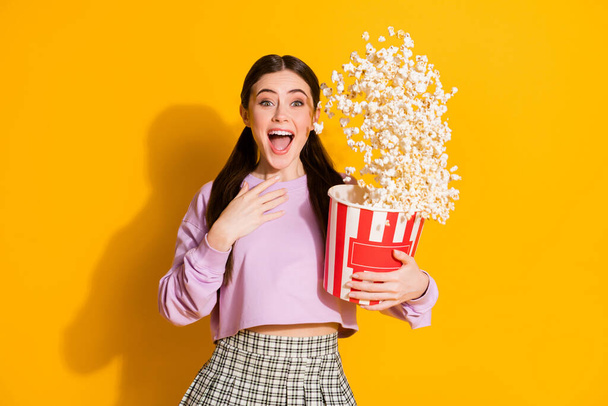 Portrait of amazed enthusiastic girl watch incredible funky series hold big box pop corn flying wear jumper checkered isolated over bright shine color background - Photo, Image