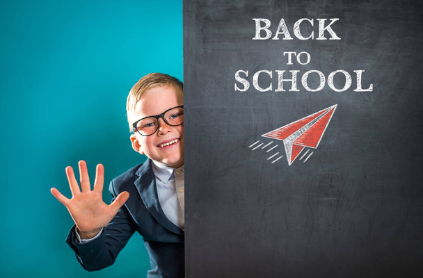 Happy smiling child with blackboard blank. Back to school concept. Little genius in glasses wave hello. - Foto, imagen