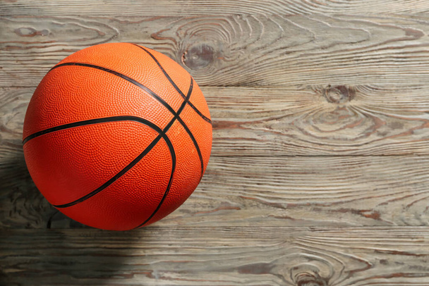 Pelota para jugar al baloncesto sobre fondo de madera
 - Foto, Imagen