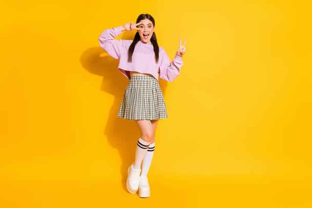 Full length body size view of her she nice attractive lovely charming crazy glad slim cheerful cheery girl having fun showing v-sign isolated over bright vivid shine vibrant yellow color background - Foto, Bild