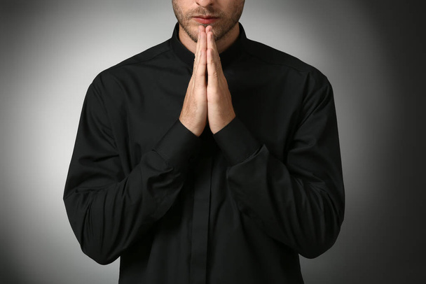 Красивый молящийся священник на тёмном фоне
 - Фото, изображение