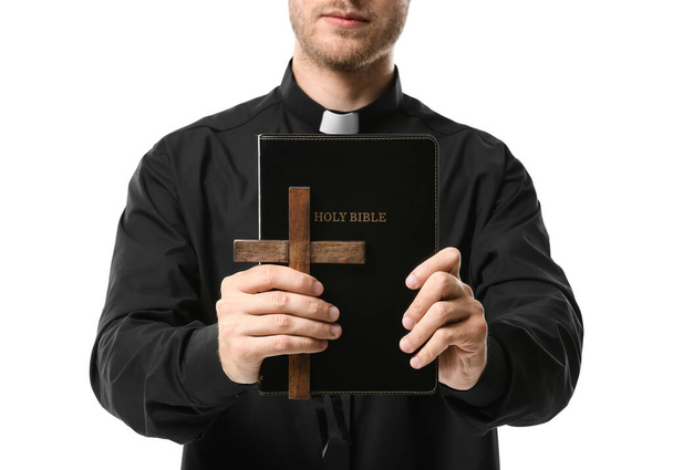 Beau prêtre avec croix et Bible sur fond blanc - Photo, image