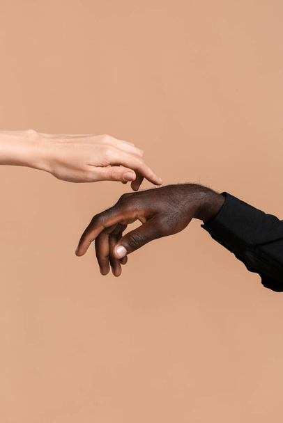 Manos de mujer caucásica y hombre afroamericano sobre fondo de color. Concepto de racismo
 - Foto, imagen