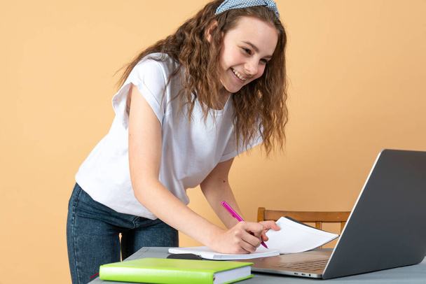 Χαμογελαστό κορίτσι που χρησιμοποιεί φορητό υπολογιστή, φοιτήτρια που σπουδάζει στο σπίτι, ψηφιακή εκπαίδευση, έφηβος που πληκτρολογεί στο διαδίκτυο περιήγησης στον υπολογιστή, blogger influencer που μιλάει στο διαδίκτυο στα κοινωνικά δίκτυα - Φωτογραφία, εικόνα
