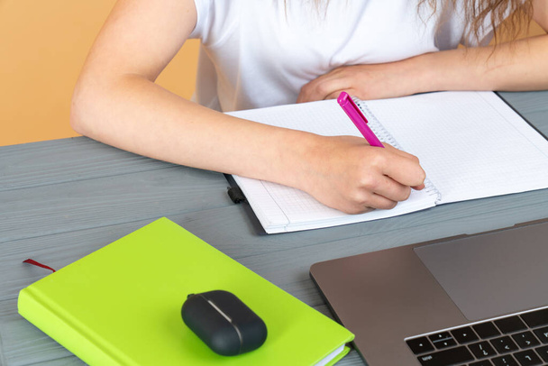 Gros plan d'une femme écrivant à la main dans un agenda sur un bureau à la maison ou au bureau - Photo, image