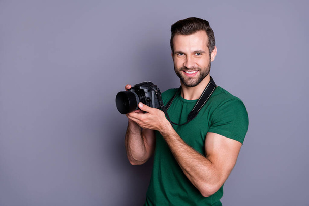 Portrait of cheerful man paparazzi hold dslr camera have spring free time holiday wear good look copyspace outfit isolated over grey color background - Фото, изображение
