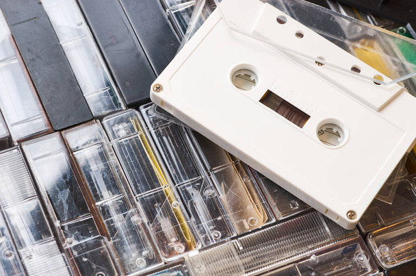 Einzelne weiße Audiokassette ohne Markierungen auf der Oberseite der Box mit vielen Bändern. Nahaufnahme - Foto, Bild