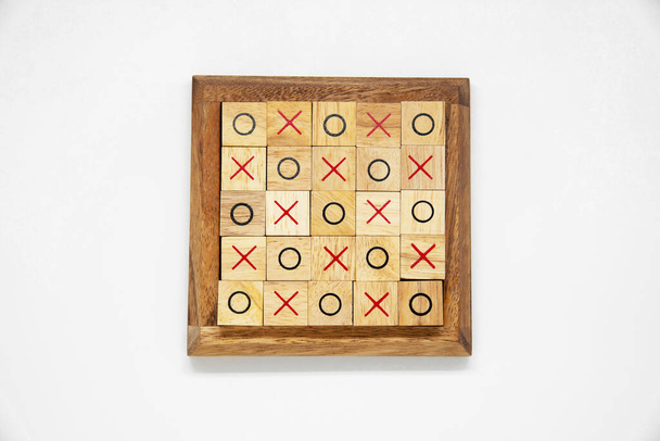 Деревянные блоки O и X для игры Tac Tac Toe лежат в деревянной раме на белом фоне для дизайна концепта - Фото, изображение