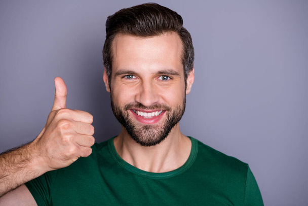 Closeup photo of attractive handsome bearded guy raise thumb finger up overjoyed expressing agreement approval wear casual green t-shirt isolated grey color background - Foto, afbeelding