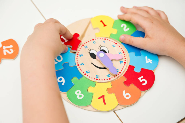 Boy learning time with wooden clock. Toy for Learning method for Children Education. Preschool or special needs tasks. Montessori methodology. - Photo, Image