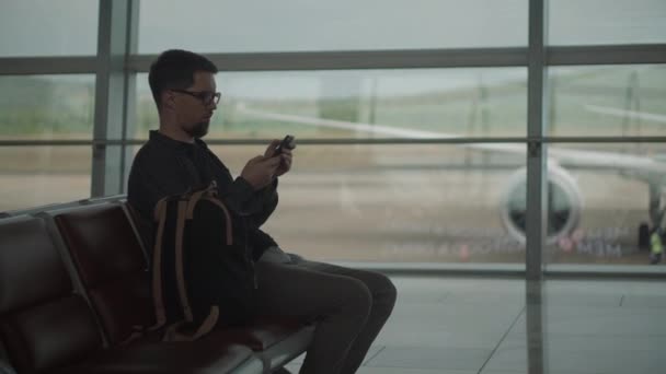 Hombre enviando mensajes a amigos antes del vuelo
 - Metraje, vídeo