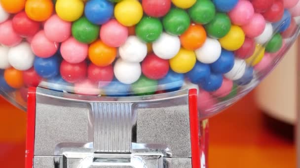 Barevné gumové kuličky v klasickém automatu, USA. Mnohobarevné žvýkačky, retro dávkovač na mince. Žvýkání žvýkaček jako symbol dětství a léta. Smíšené sladkosti ve vinobraní automatu - Záběry, video